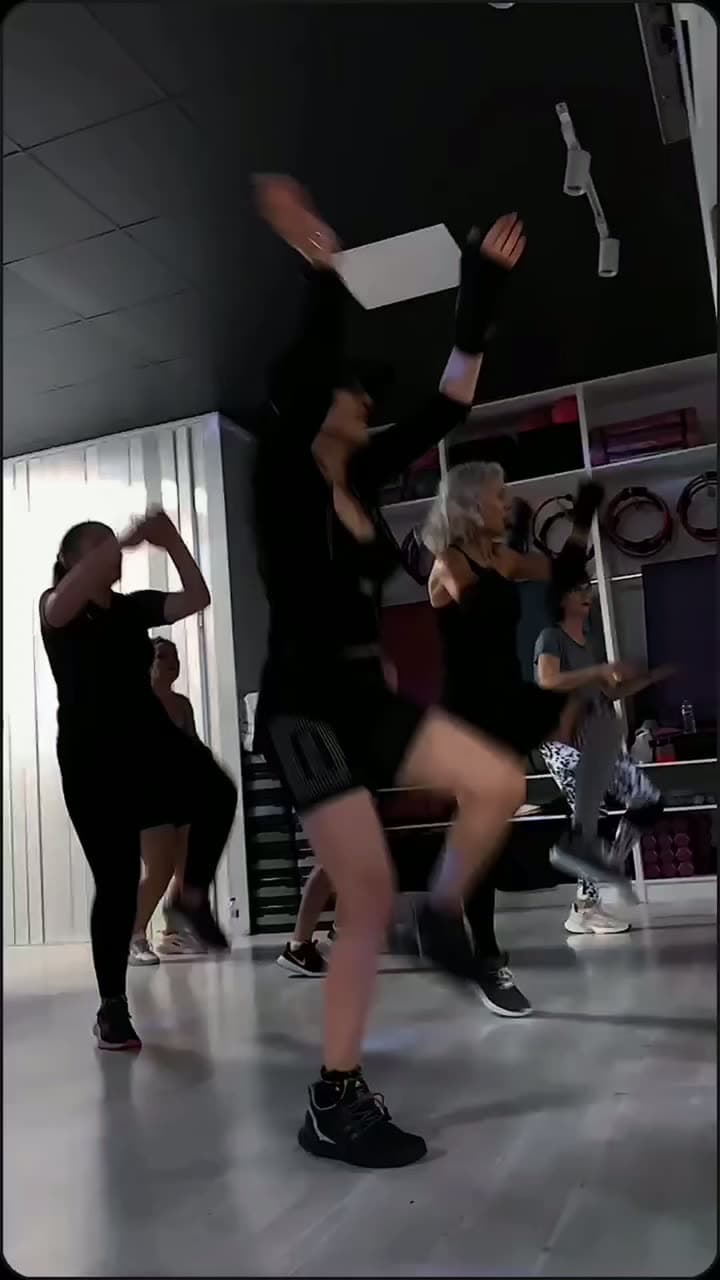 Siyah kıyafetlerle yüksek tempoda zumba yapan kadın grubu